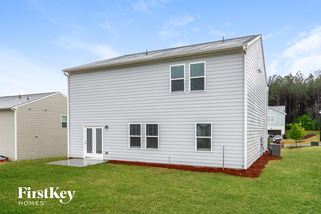 the outside of a white house with a yard and grass