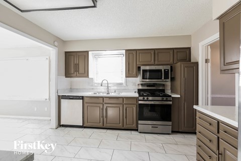 a kitchen with brown cabinets and a sink and a stove