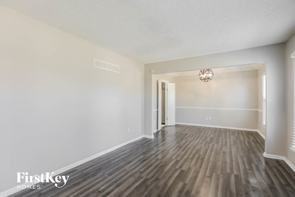 an empty living room with white walls and wood floors