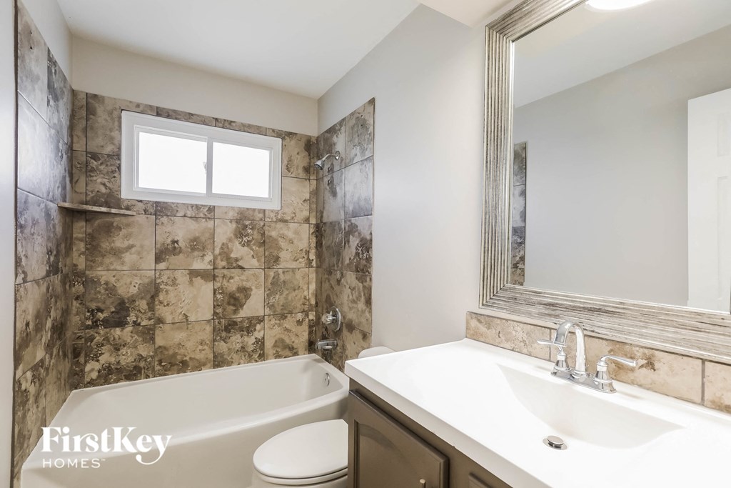 a bathroom with a tub and a sink and a mirror
