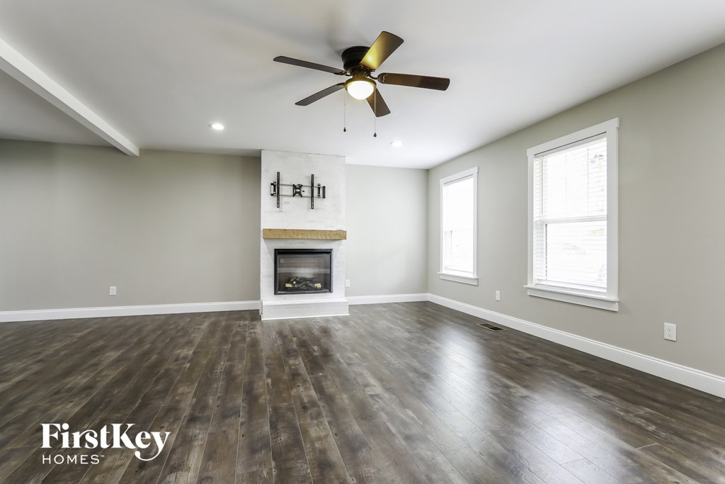 a living room with a fireplace and a ceiling fan