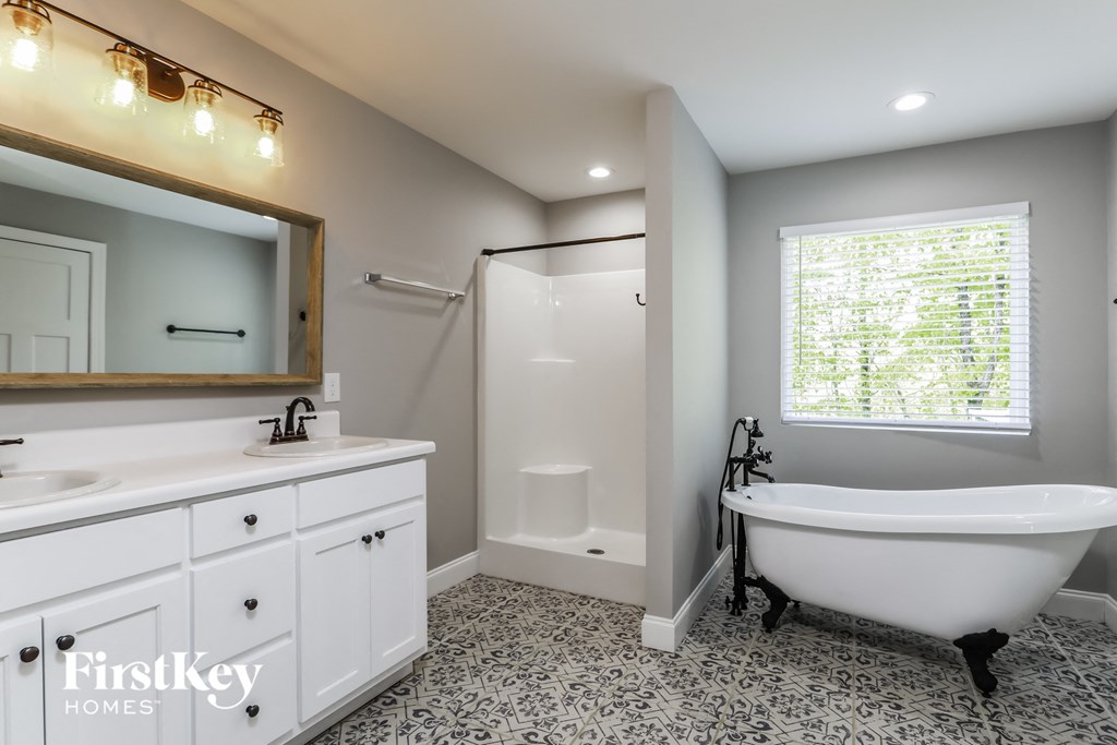 a white bath tub in a bathroom with a sink and a mirror