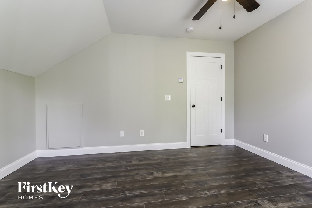 the living room of a home with wood flooring and a ceiling fan