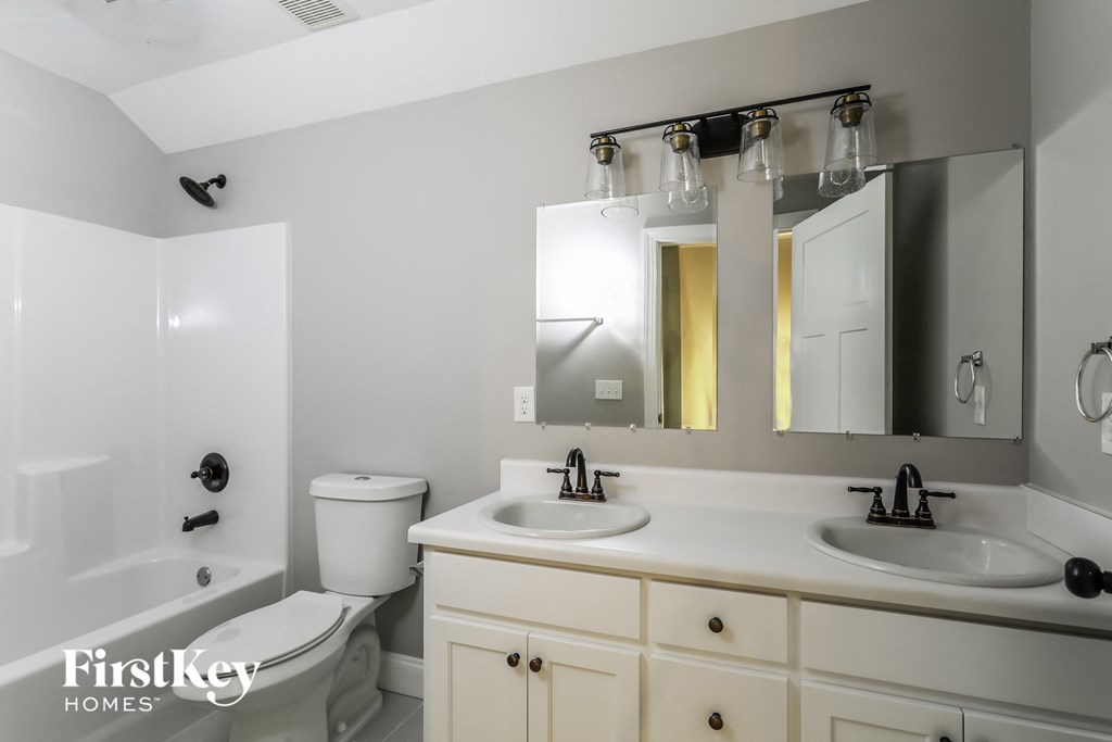 a white bathroom with two sinks and a tub and a toilet