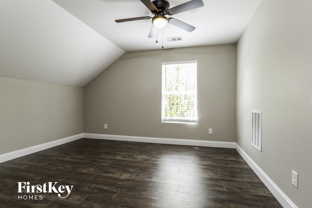 an empty room with a ceiling fan and a window