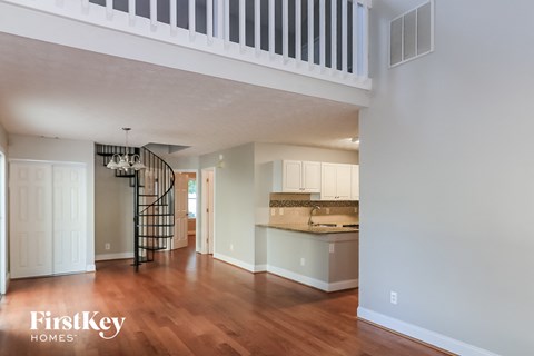 A spacious kitchen with a staircase in the background.