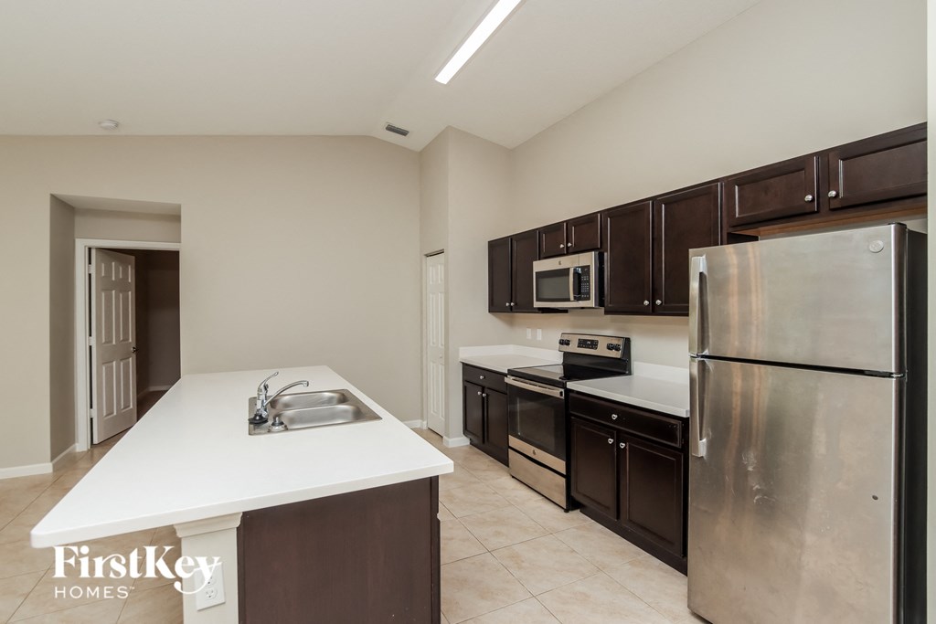 A kitchen with a white countertop and stainless steel appliances.