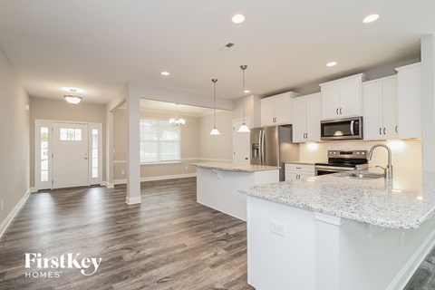 a kitchen with white cabinets and a marble counter top