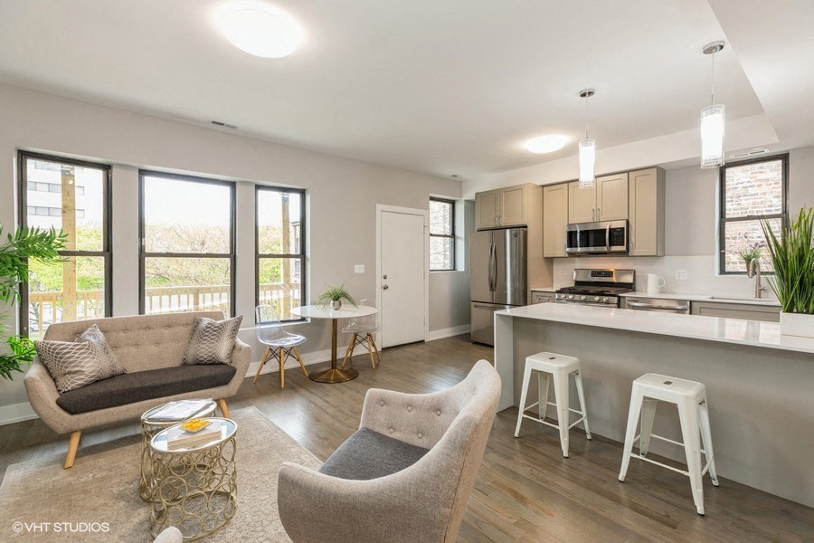 an open kitchen and living room with a bar and stools