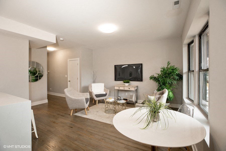 a living room and dining room with a table and chairs