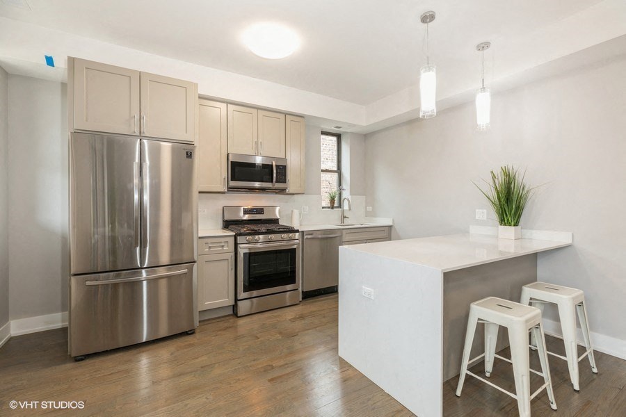 a kitchen with stainless steel appliances and a bar with stools