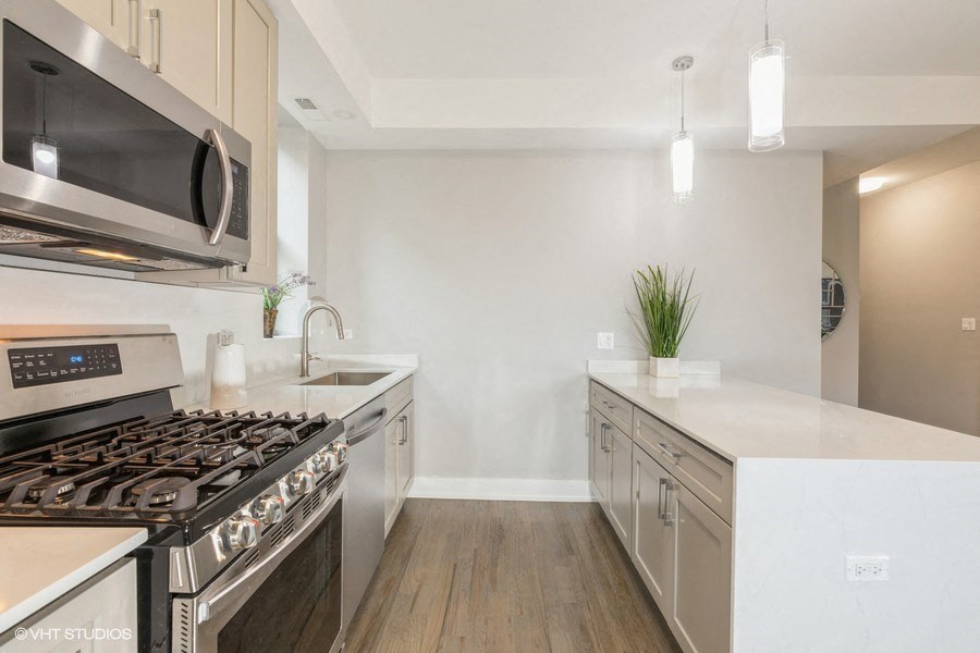 a kitchen with stainless steel appliances and white counter tops