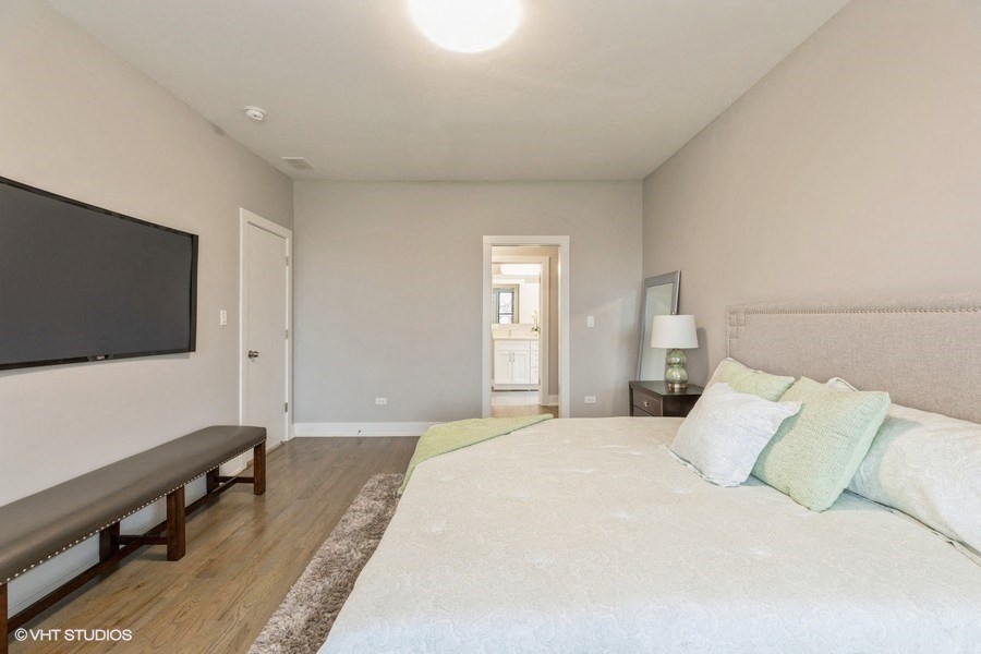 a master bedroom with a large bed and a tv