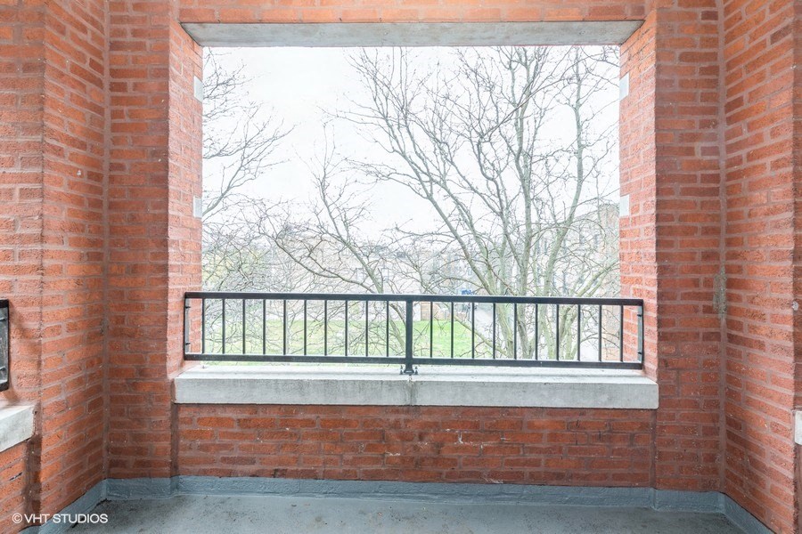 a balcony with a brick wall and a window