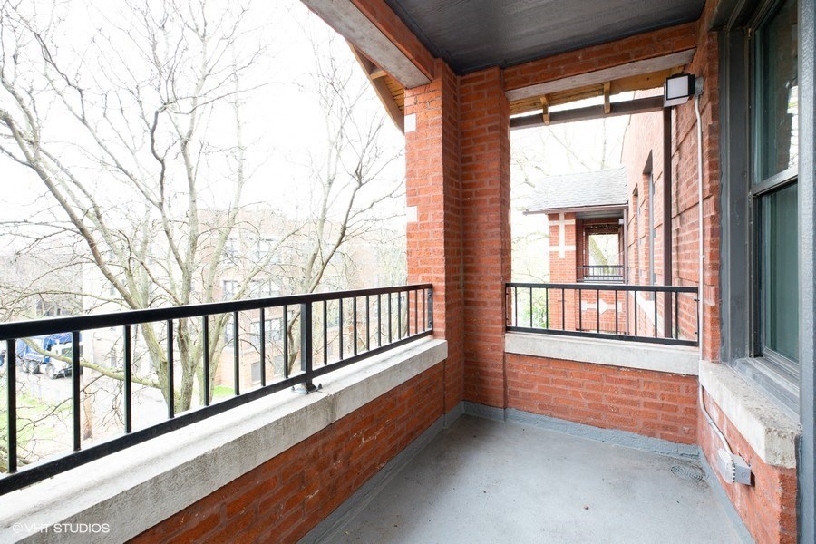 a balcony with a brick wall and a large window