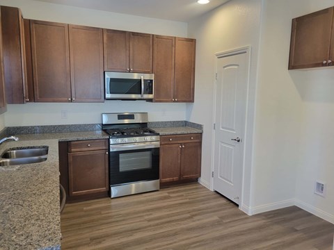 A kitchen with wooden cabinets and a granite countertop.