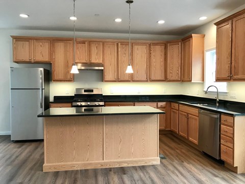 a kitchen with wooden cabinets and stainless steel appliances