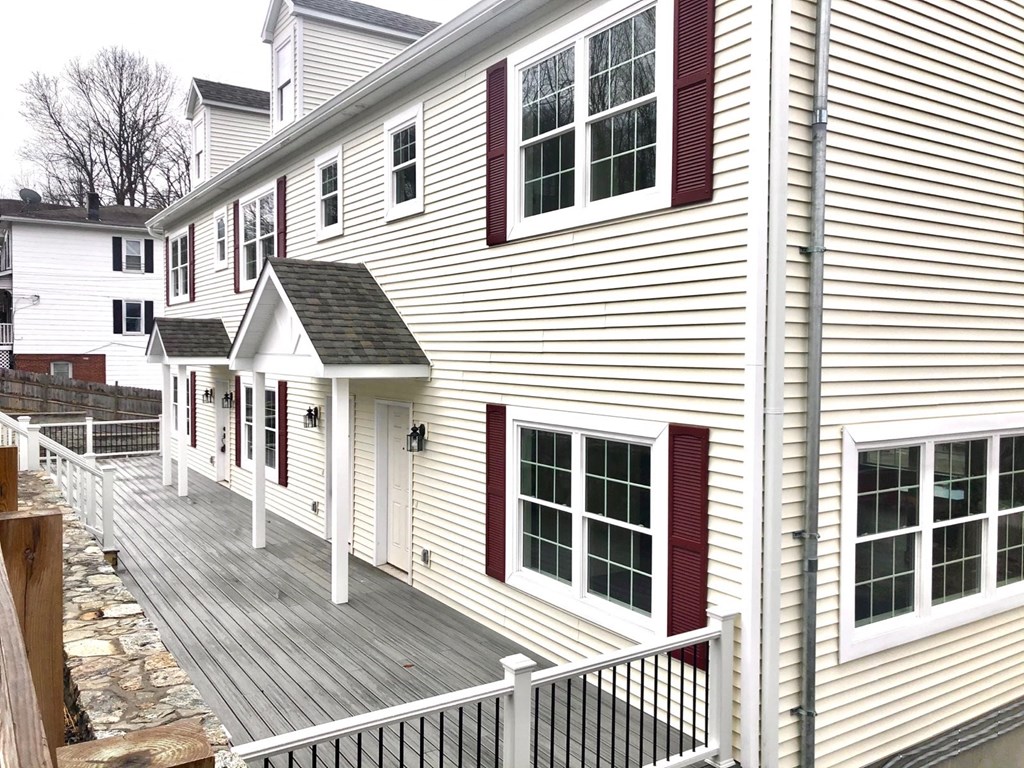 a white house with red shutters and a wooden deck
