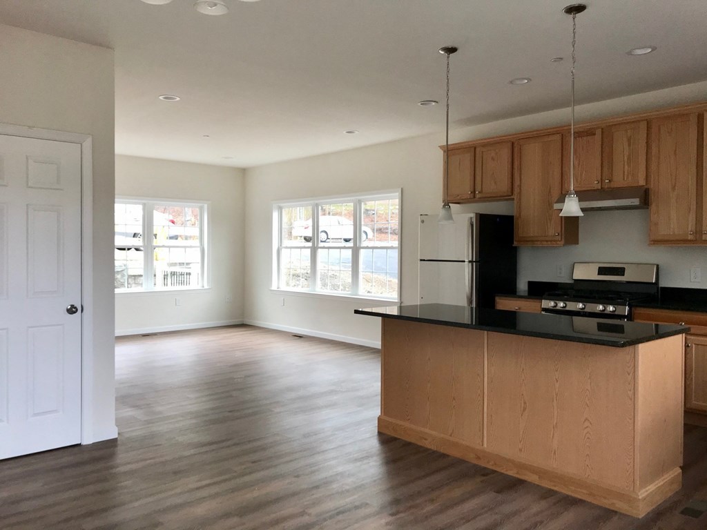 an empty kitchen with wooden cabinets and a black counter top