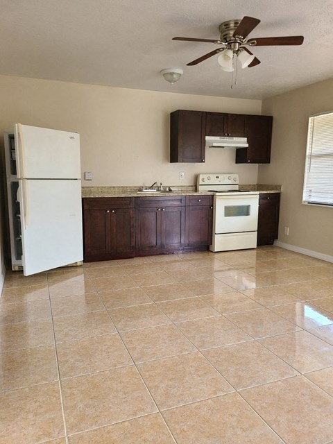 an empty kitchen with a refrigerator and a stove