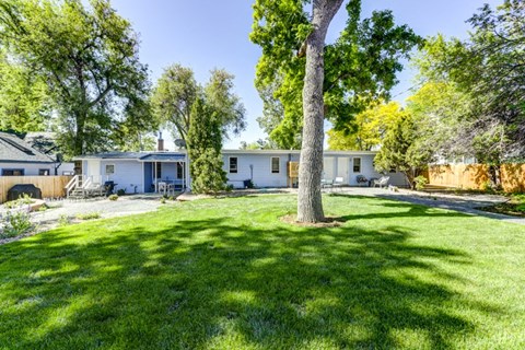a white house with a yard and trees in front of it