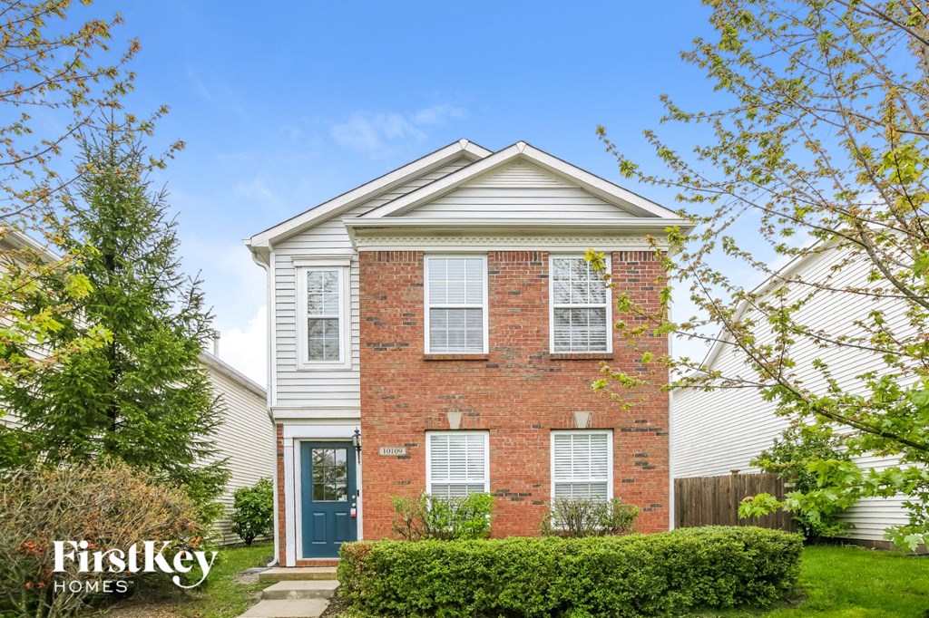 A brick house with a blue door and a white window.