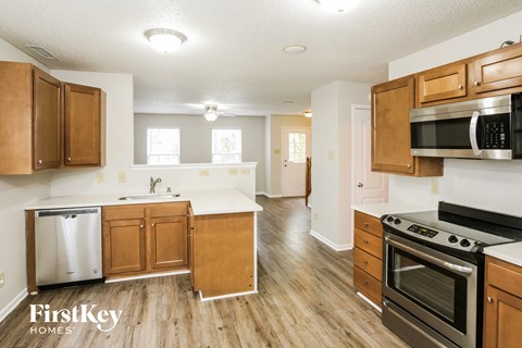 A kitchen with wooden cabinets and a stainless steel refrigerator.