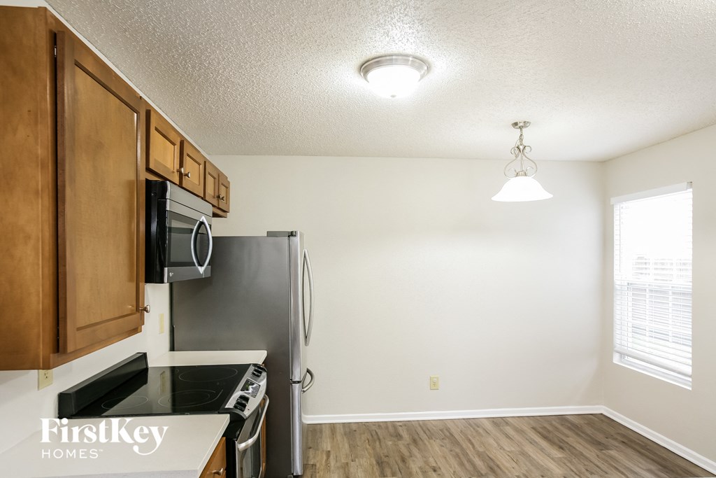 A kitchen with wooden cabinets and a black countertop.