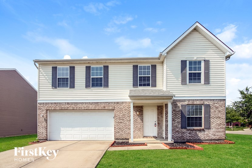 A two-story house with a garage is for sale.