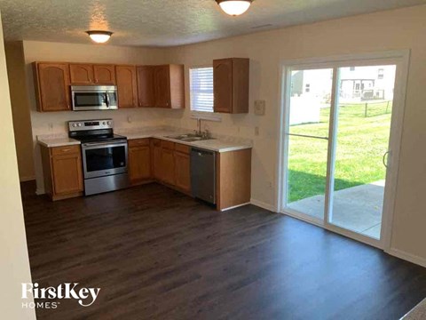 A kitchen with wooden cabinets and a stainless steel dishwasher.