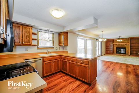 a kitchen with wooden cabinets and a stove and a fireplace