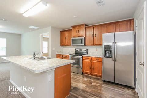 A kitchen with a white counter top and wooden cabinets.
