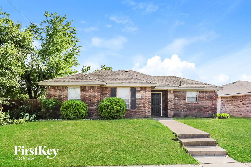 A brick house with a black door and a small porch.