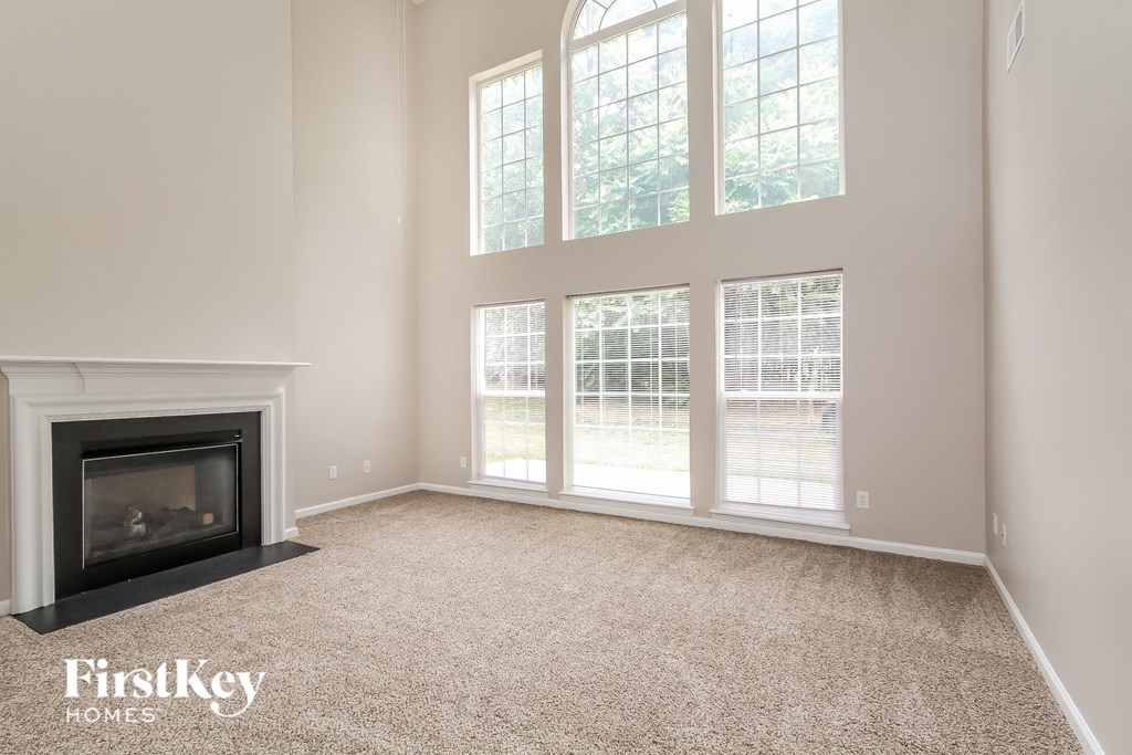 a living room with a fireplace and large windows