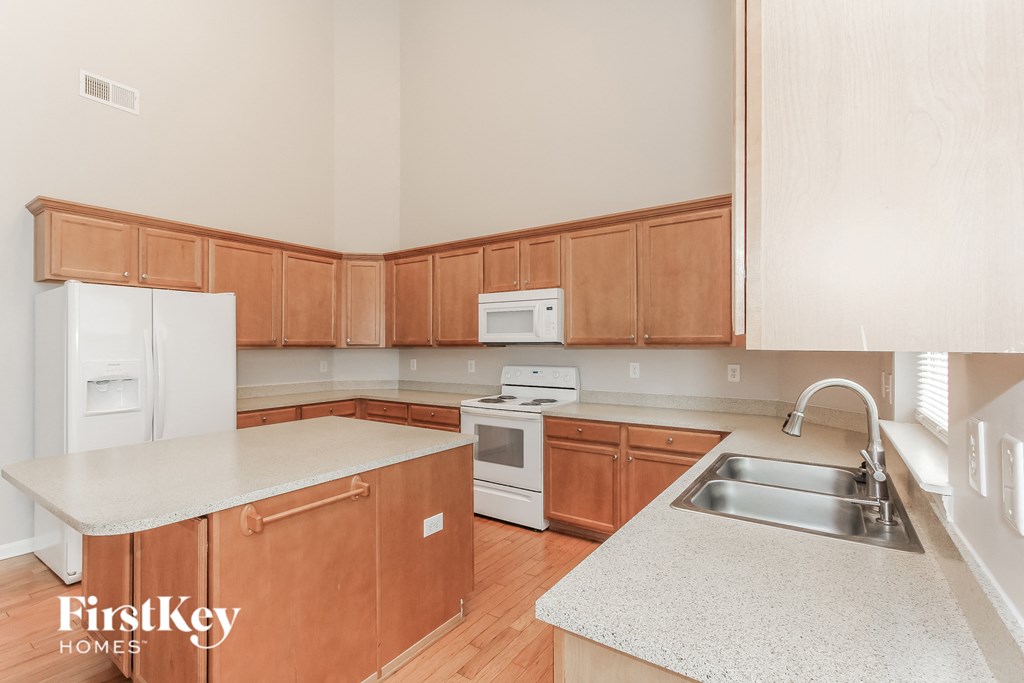 a kitchen with wooden cabinets and white counter tops and a sink