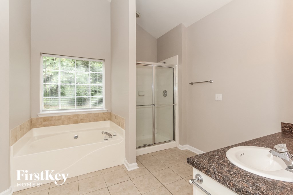 a bathroom with a tub and a shower and a sink