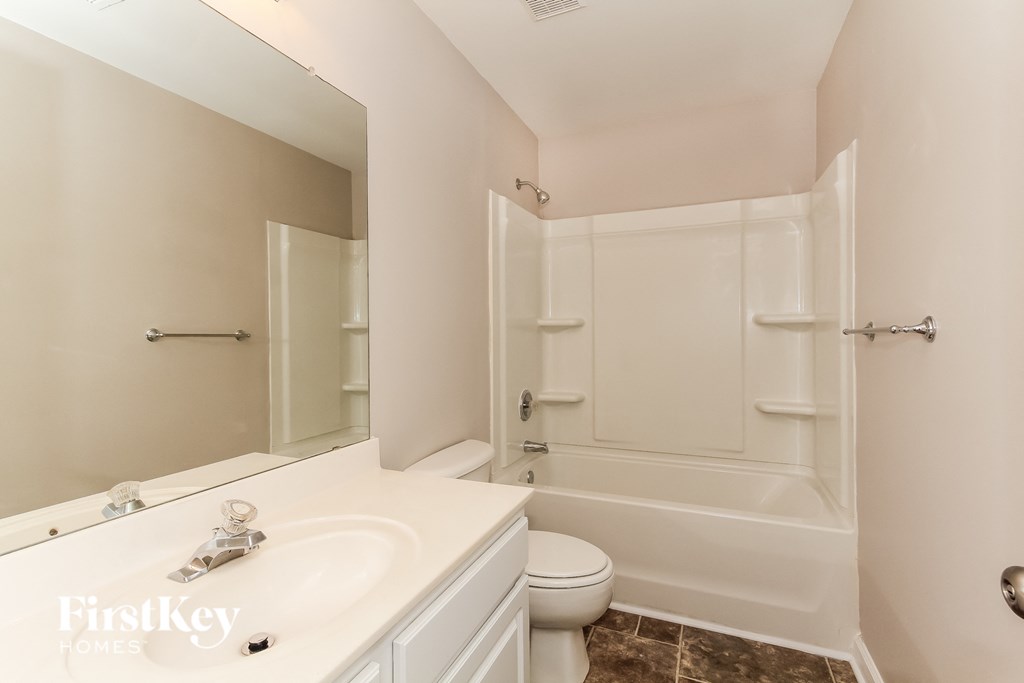 a white bathroom with a sink and a toilet and a shower