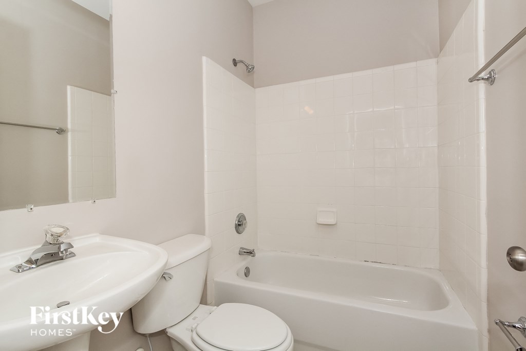 a white bathroom with a sink toilet and bath tub