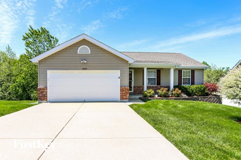 a house with a white garage door in front of a lawn