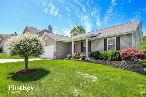a house with a lawn and a tree in front of it