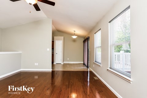 an empty living room with wood flooring and large windows