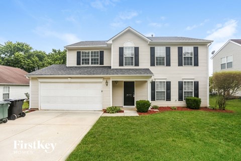A two-story house with a garage and a driveway.