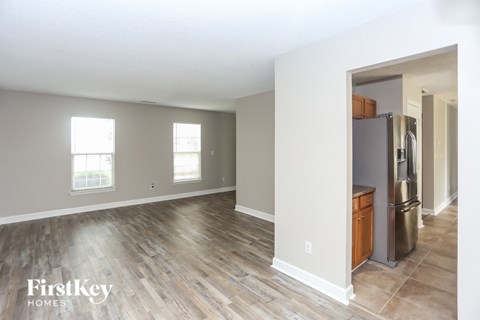 A kitchen area with a refrigerator and a wooden cabinet.