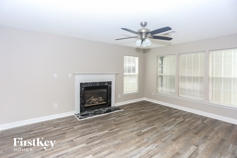 A living room with a fireplace and a fan.