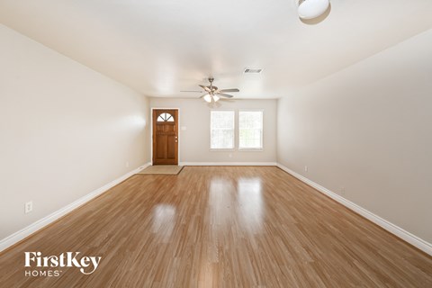 A room with wooden flooring and a ceiling fan.