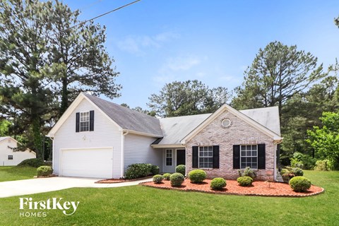 A house with a white garage door is for sale by FirstKey Homes.