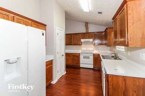 A kitchen with wooden cabinets and a white fridge.