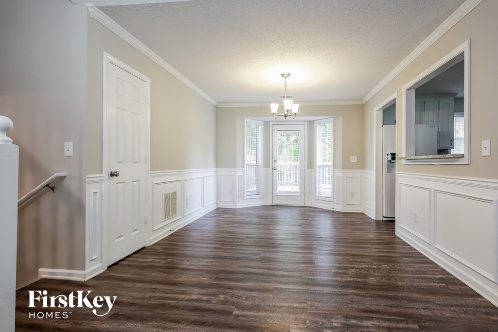 an empty living room with wood floors and white walls