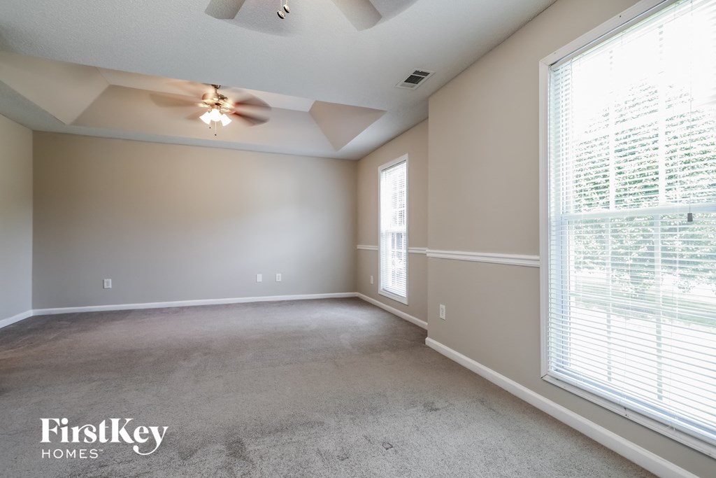 a living room with a ceiling fan and a large window