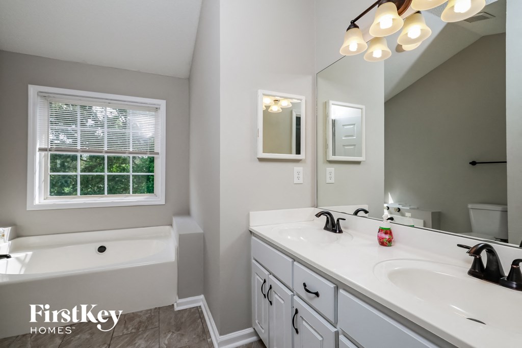 a bathroom with a sink and a tub and a mirror
